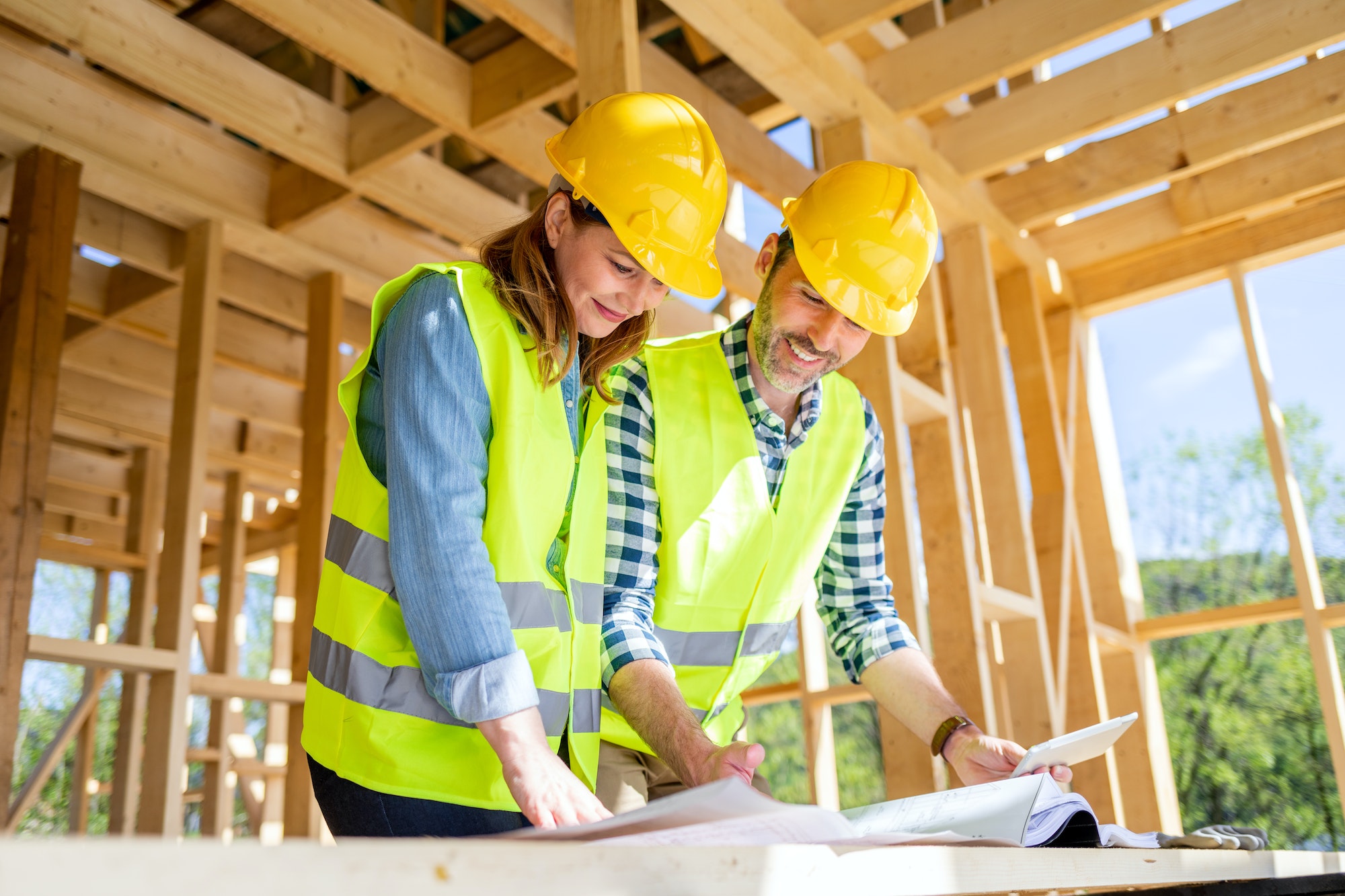 Team engineer and architect are meeting to plan for new project of wood frame house on building site